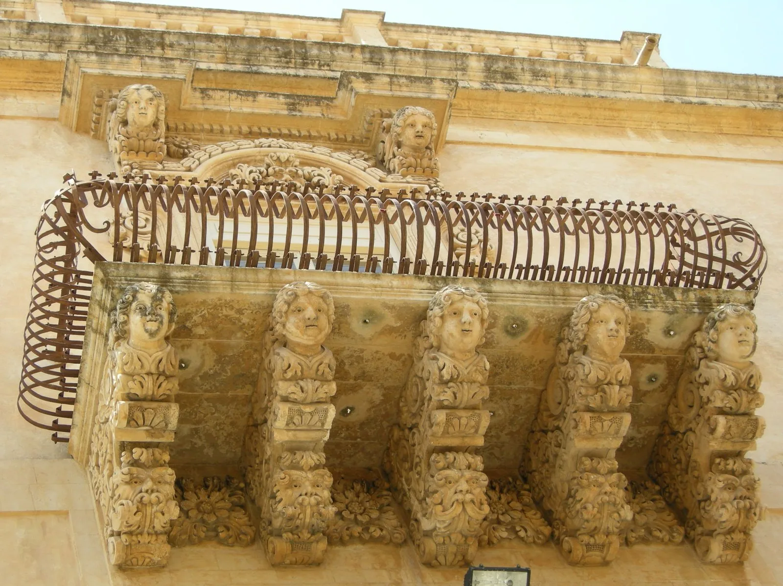 Le mensole scolpite a figure sotto i balconi di Palazzo Nicolaci a Noto